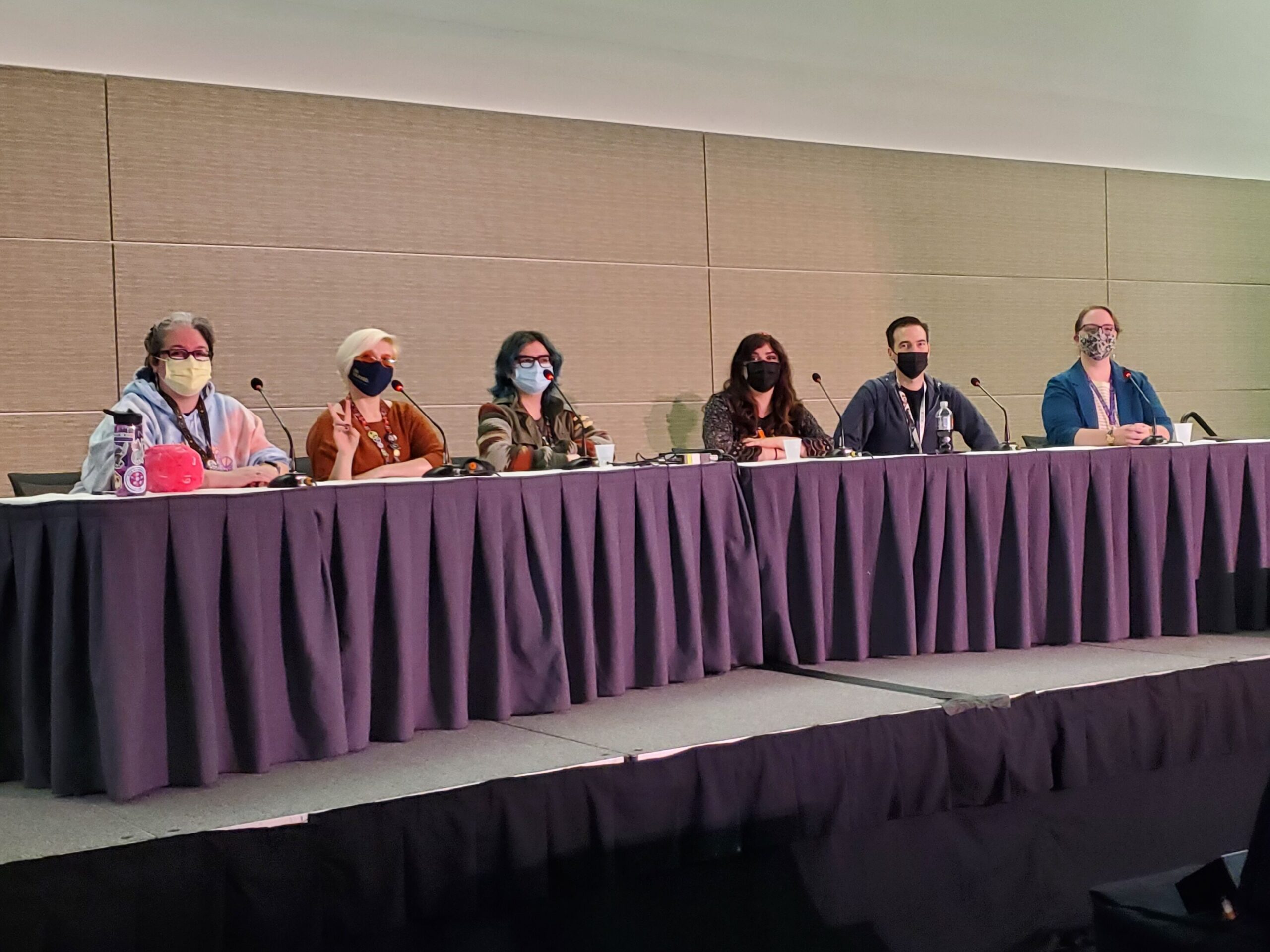 A panel of people sit at a table 